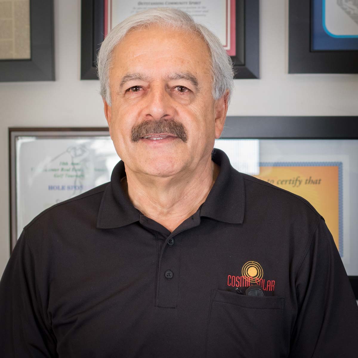 A man with a mustache is wearing a black shirt that says certified