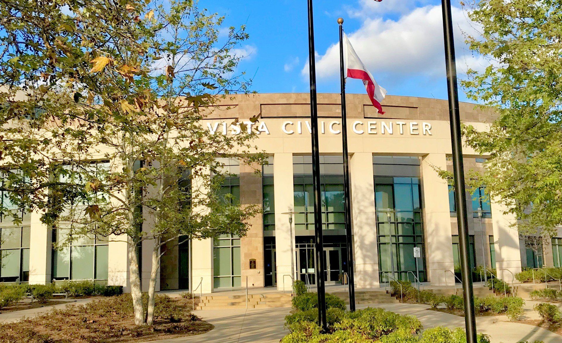 A view of the vista civic center with flags in front of it