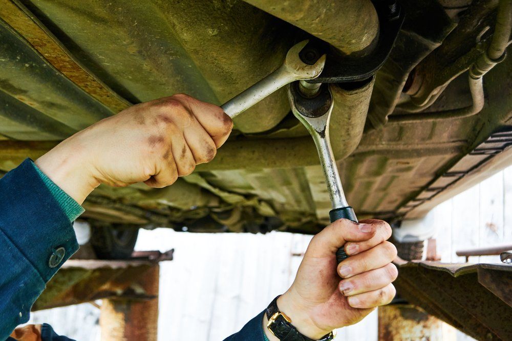 Mechanic Repairing The Exhaust System Of The Car - Specialist Mechanics in Cairns, QLD