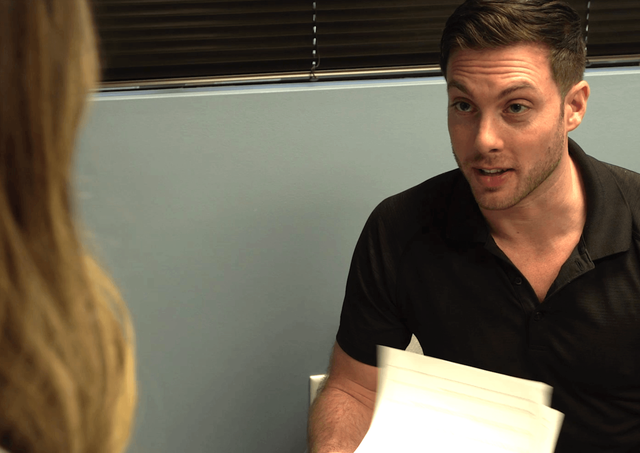 A man in a black shirt is talking to a woman