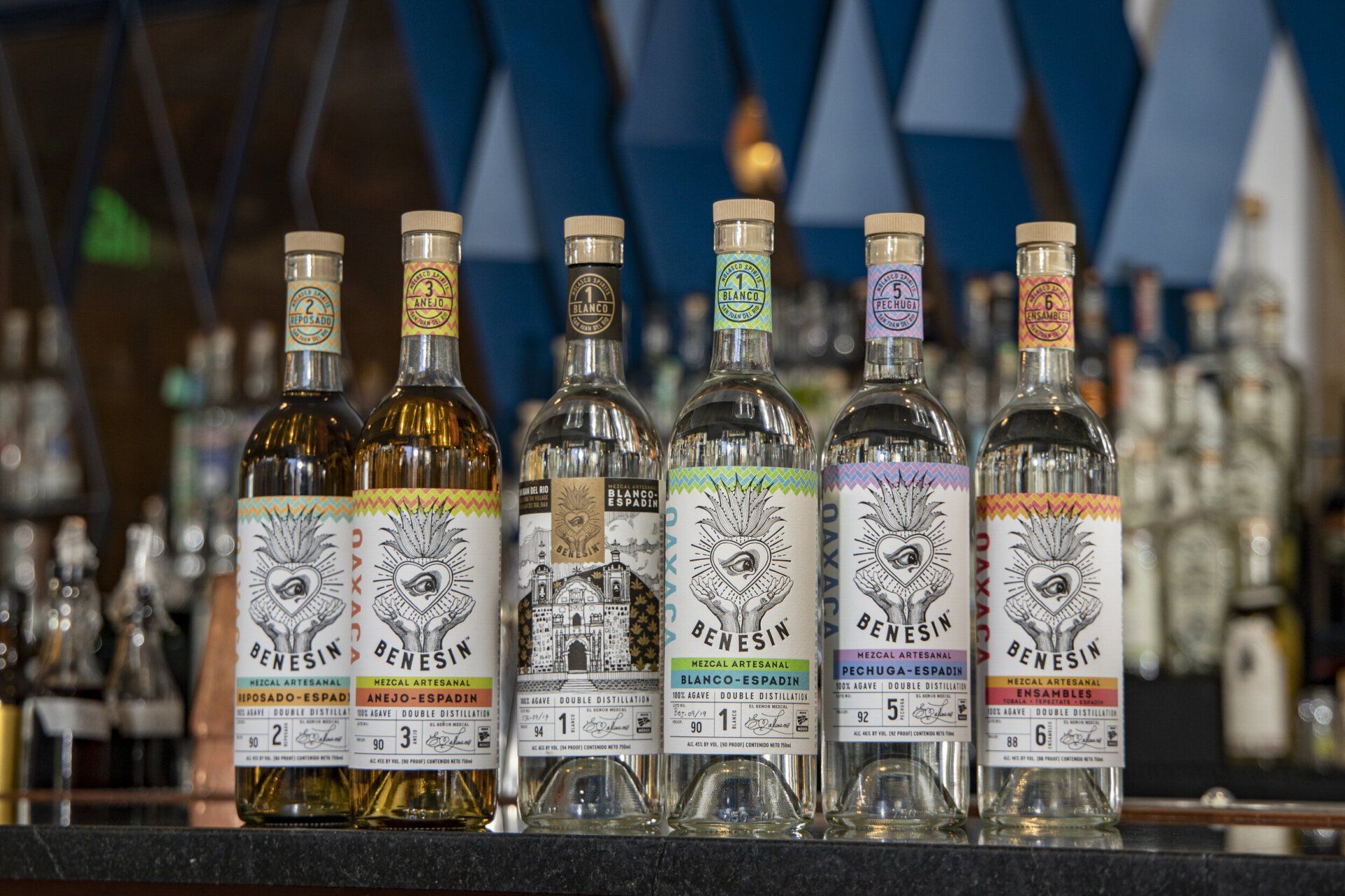 Several bottles of alcohol are lined up on a bar