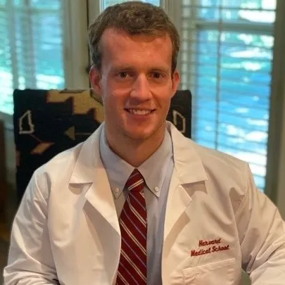 Man in white lab coat smiles; 