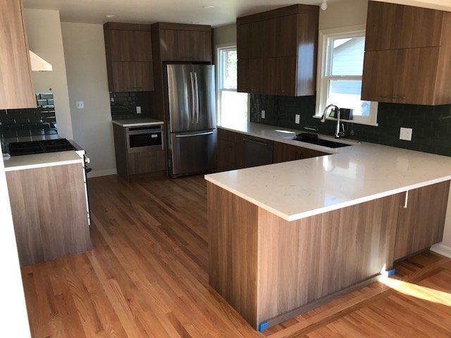 Modern kitchen with wood cabinets, stainless appliances, and a large white island.