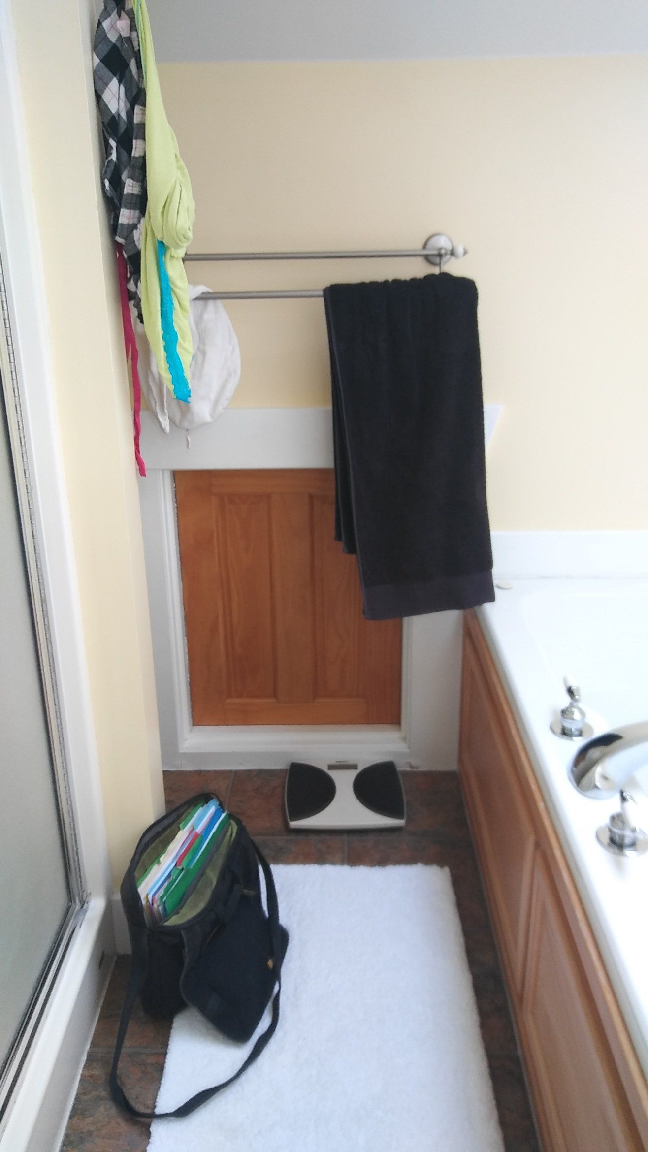 Narrow bathroom with a towel hanging above the toilet and a sink on the right.