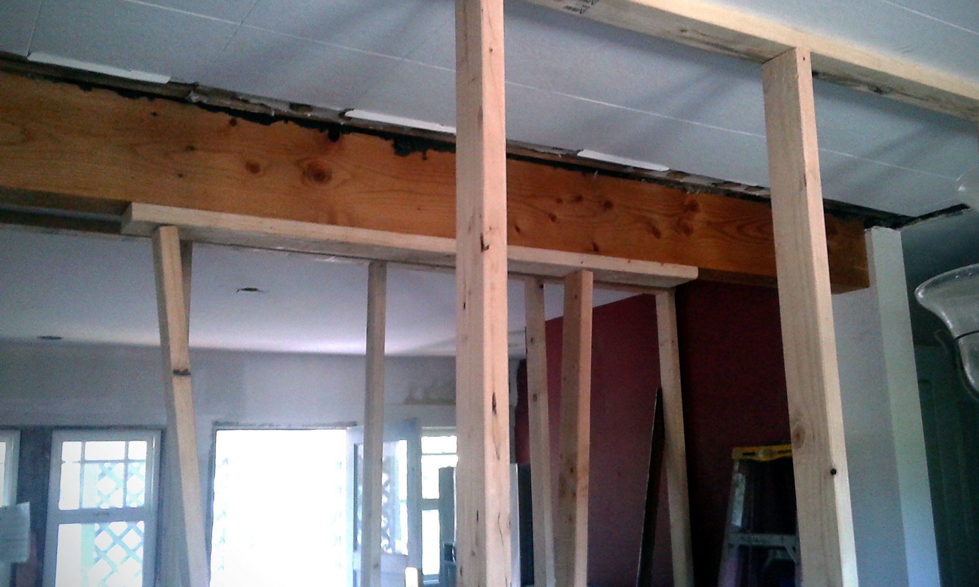 Partially framed interior with exposed wooden beams and studs during renovation