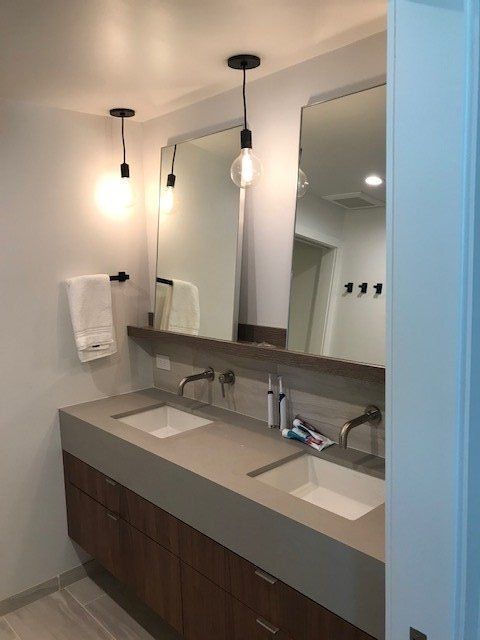 Modern bathroom vanity with double sinks, wall mirrors, and pendant lights