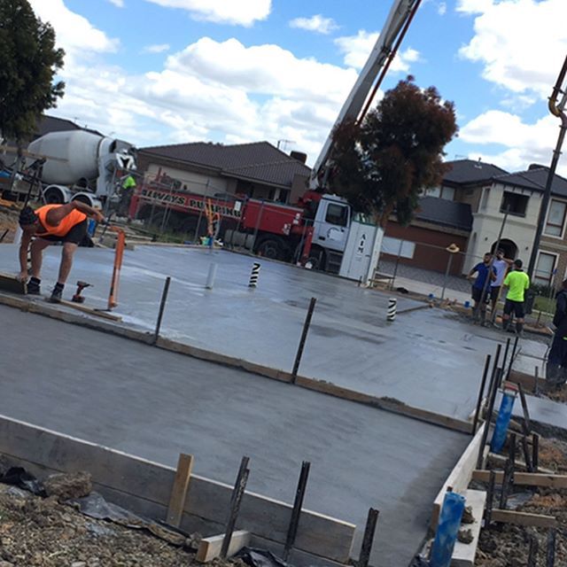 workers concreting foundation of building
