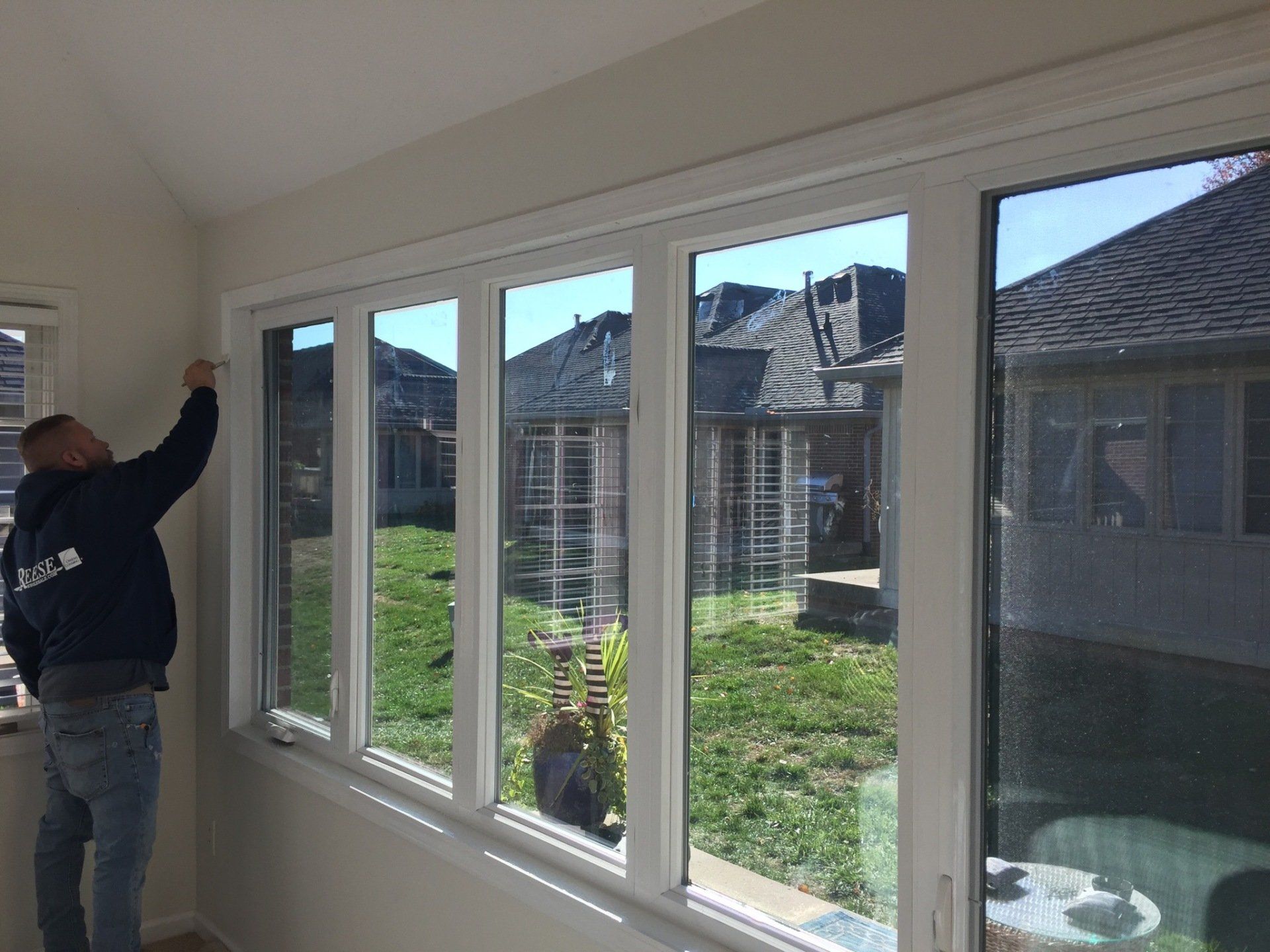 A man is standing in front of a large window in a room.