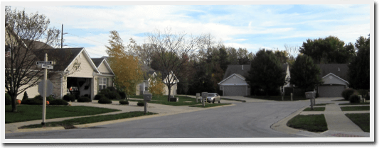 A residential neighborhood with houses and trees on a sunny day