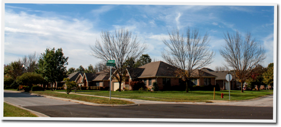 A row of houses in a residential area with a green street sign