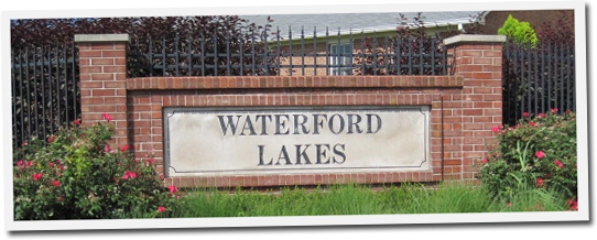 A brick wall with a sign that says waterford lakes