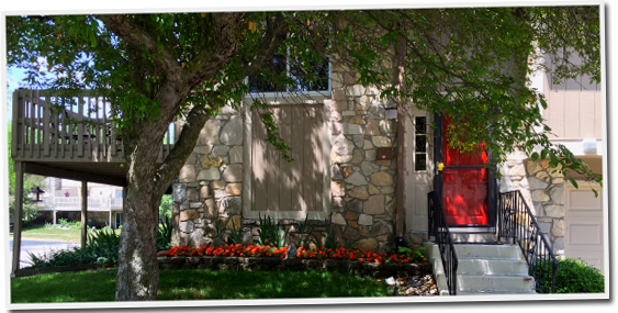 A house with a red door and a tree in front of it
