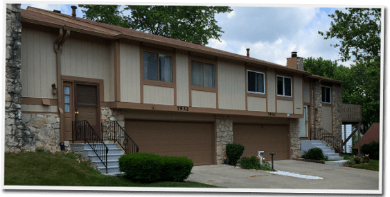 A house with two garages and stairs in front of it
