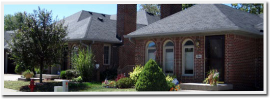 A brick house with a gray roof and arched windows