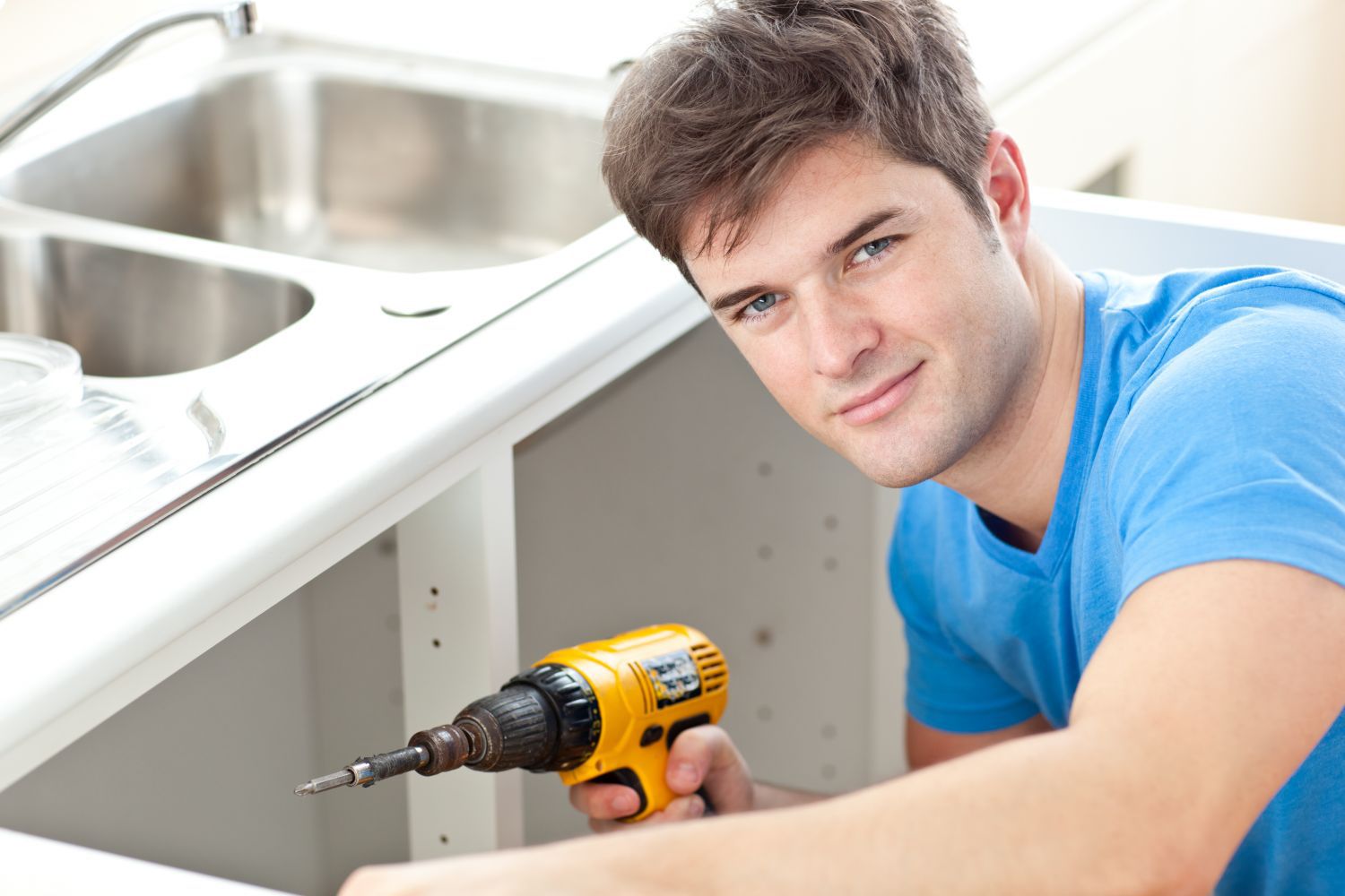 man in the process of installing custom kitchen design in Canterbury