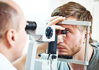 Man Getting Eyes Checked — Family Eye Care in Rochester, PA Man Getting Eyes Checked — Family Eye Care in Rochester, PA