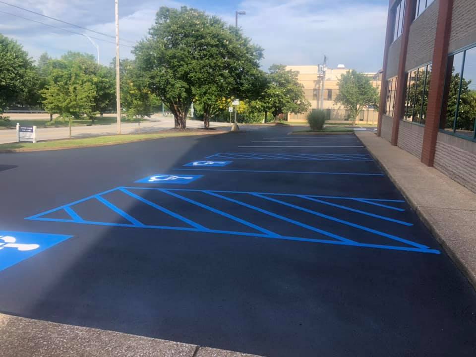 A parking lot with blue lines and a handicapped parking space.
