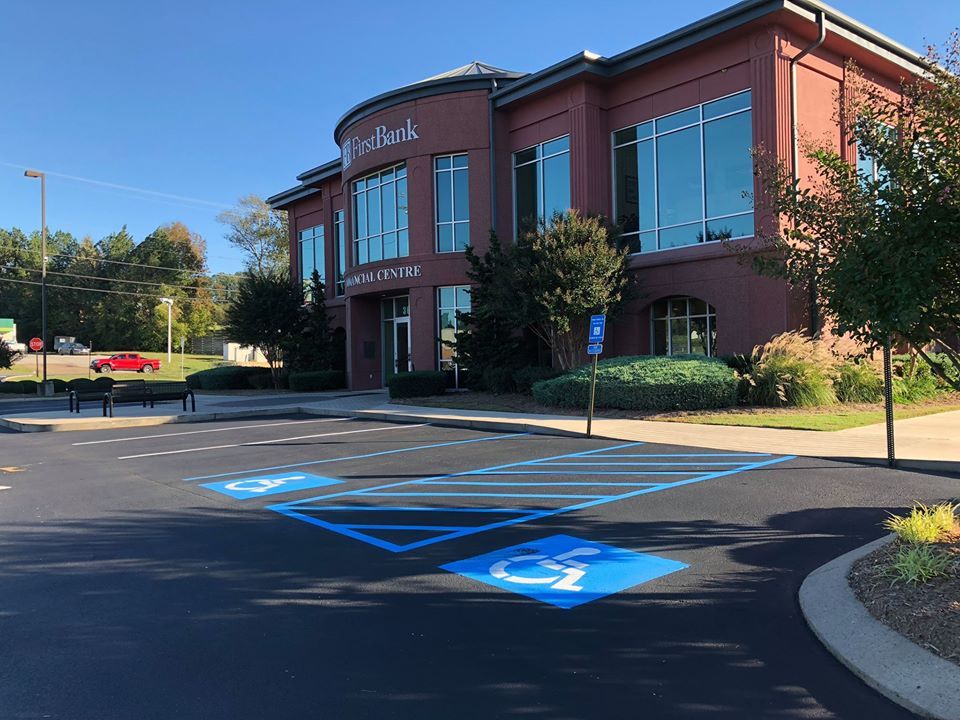 A handicapped parking spot in front of a large building