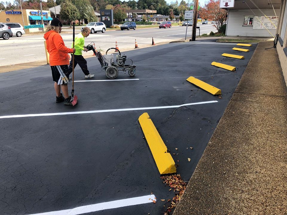 A couple of people are working on a parking lot