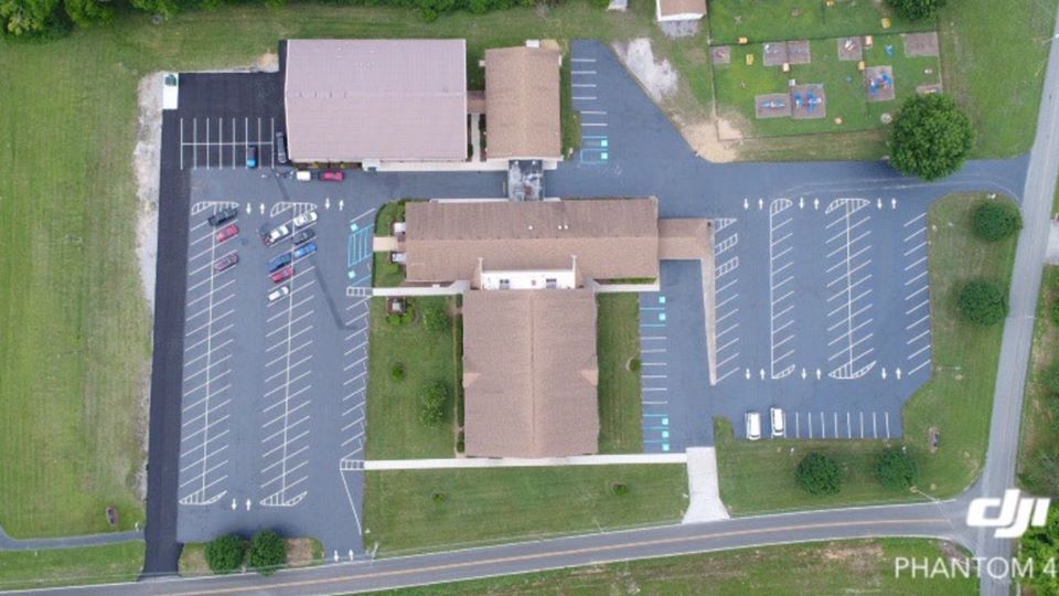 An aerial view of a church with a lot of parking spaces.