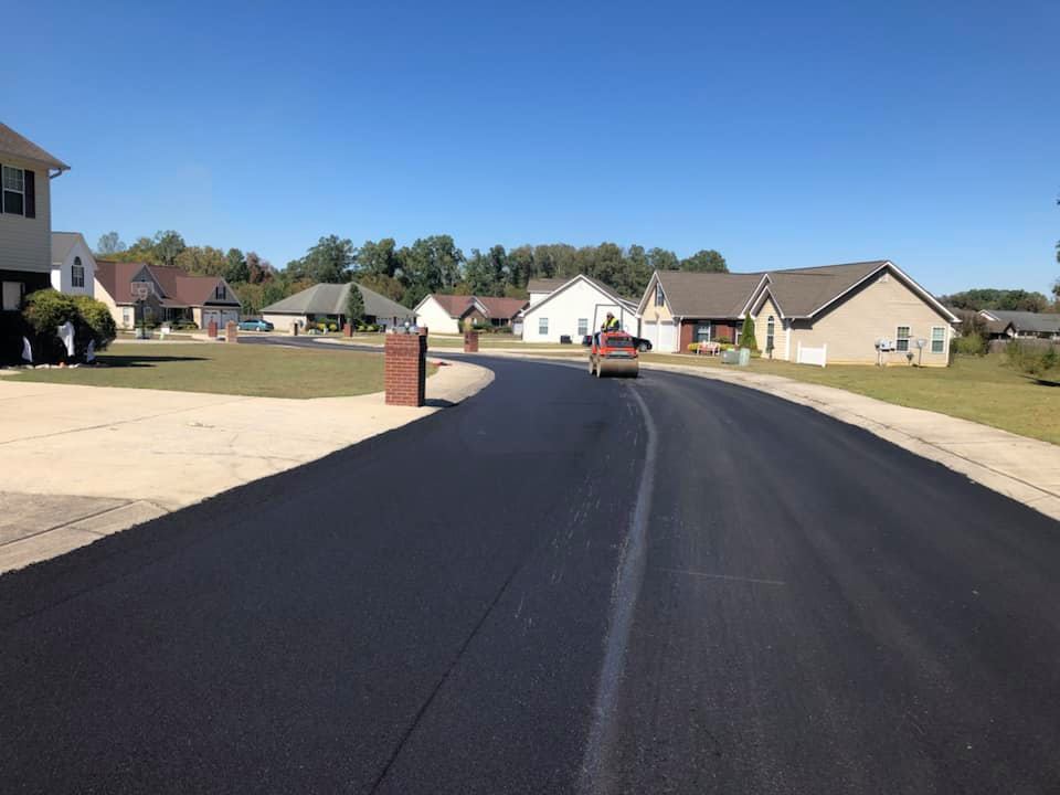 A car is driving down a road in a residential area