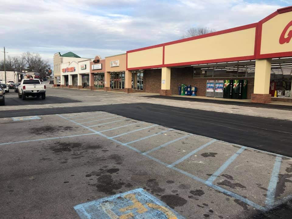 A parking lot with a handicapped parking space in front of a store.