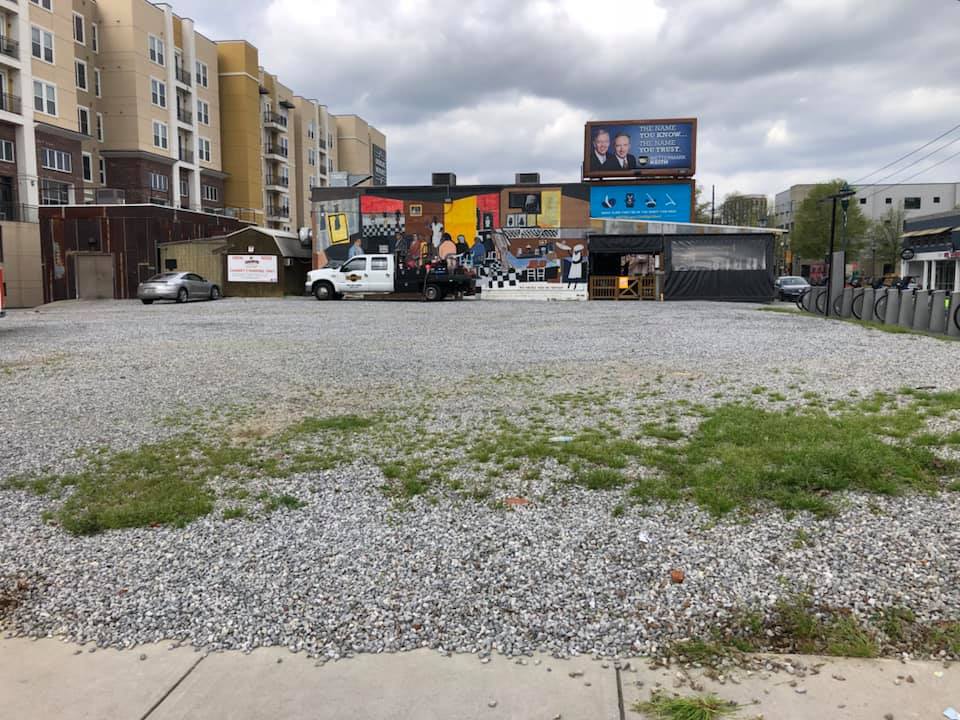 A large gravel lot with a building in the background