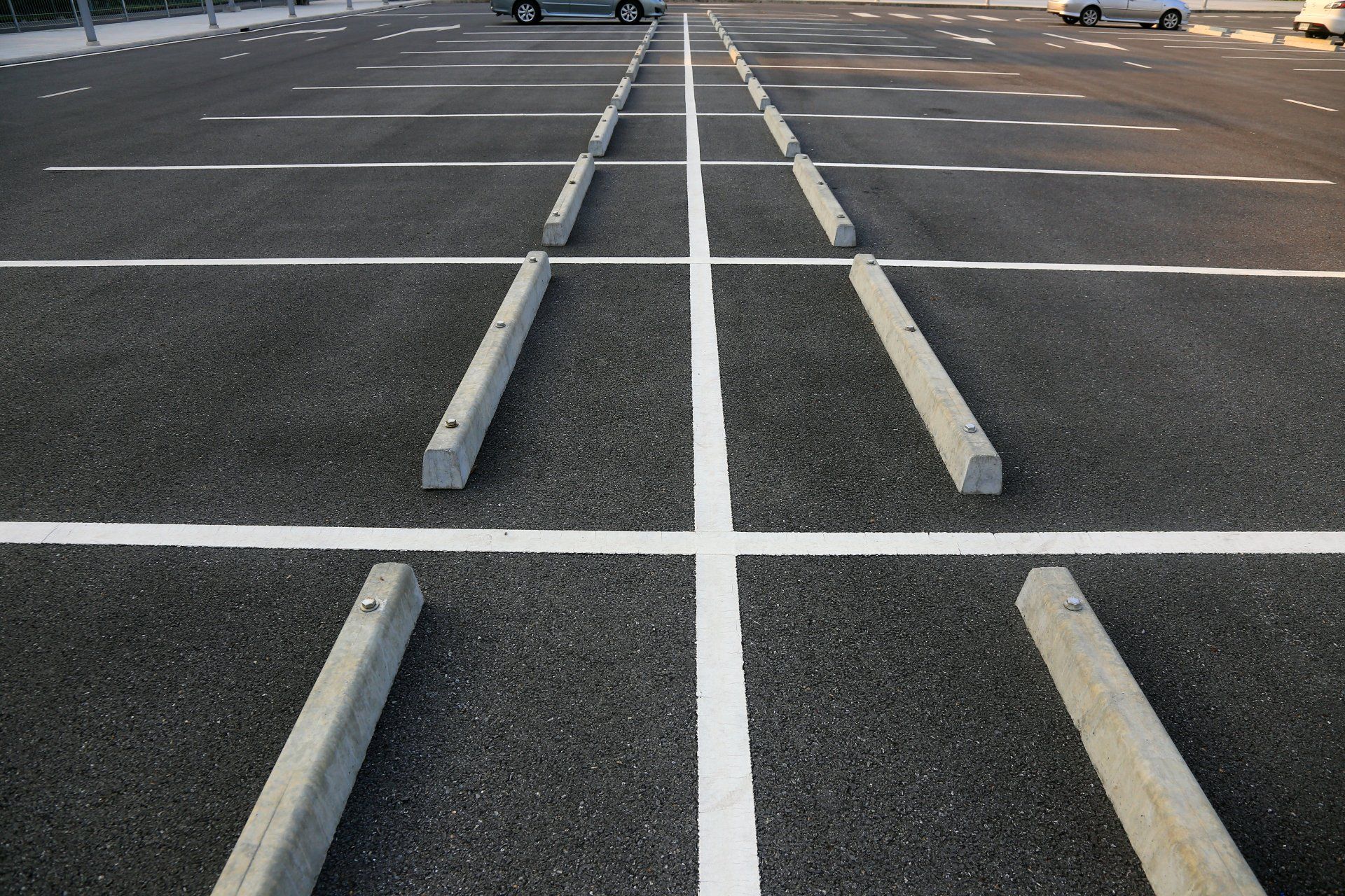 A parking lot with white lines and concrete curbs