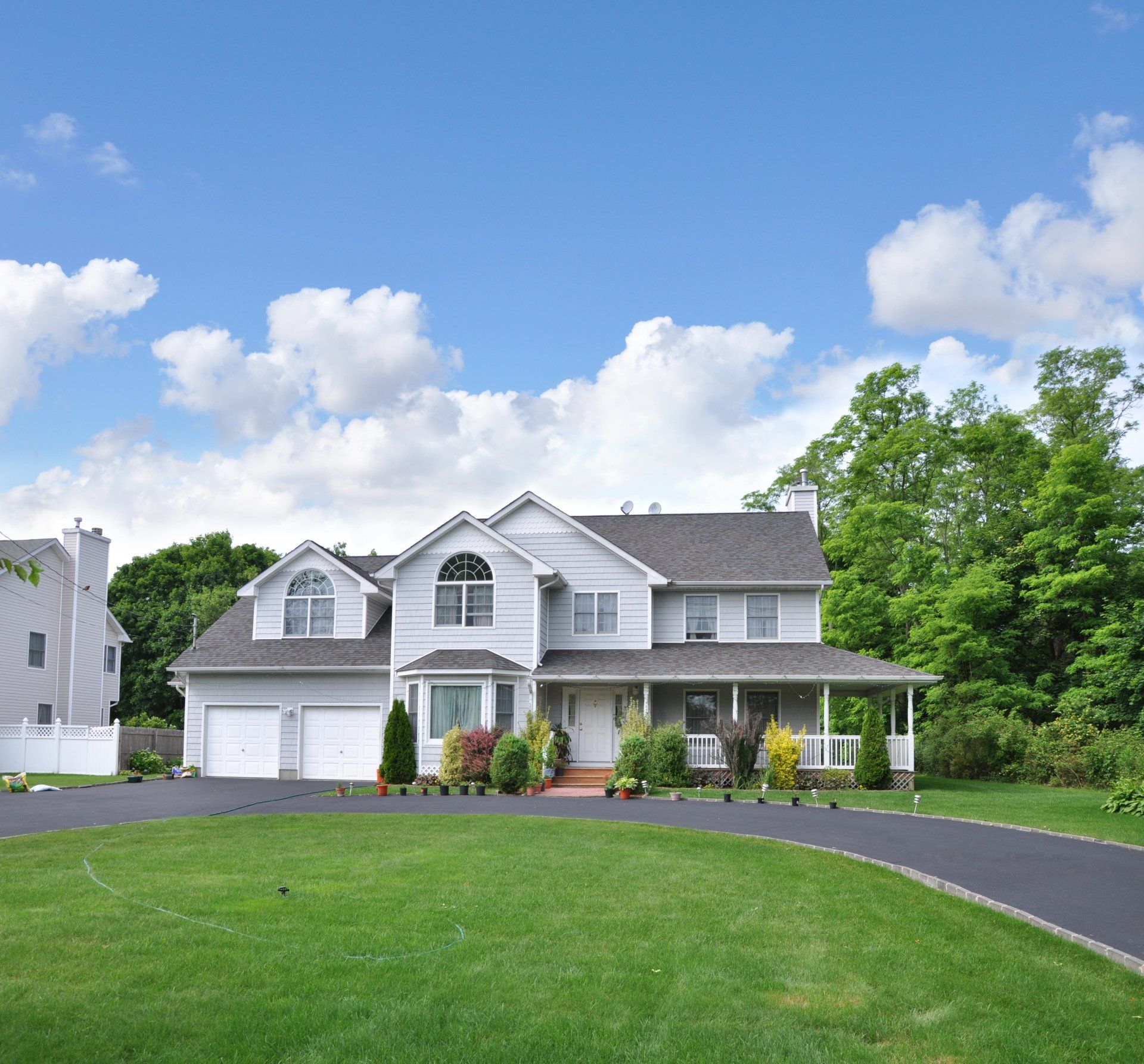 A large white house with a driveway leading to it