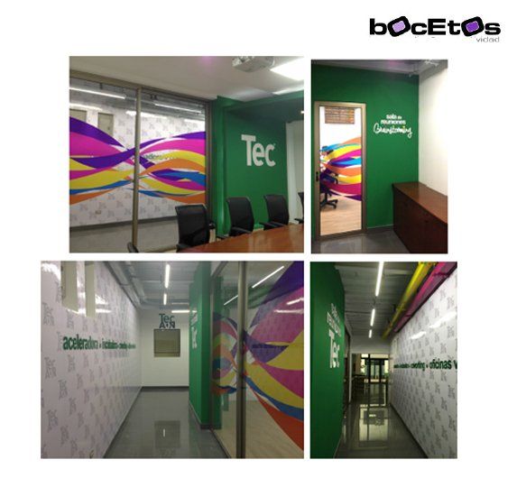 Pasillo colorido de la oficina de Tec con paredes verdes, paneles blancos estampados y detalles de mural con arcoíris.
