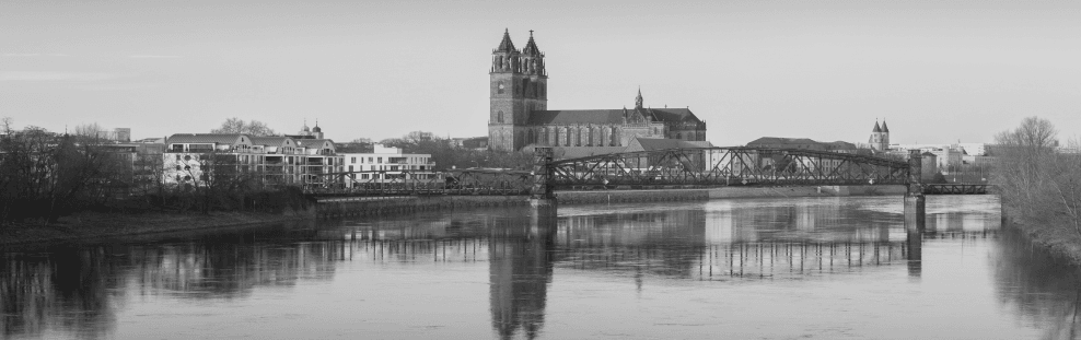 Ein Schwarzweißfoto einer Stadt mit Blick auf ein Gewässer.