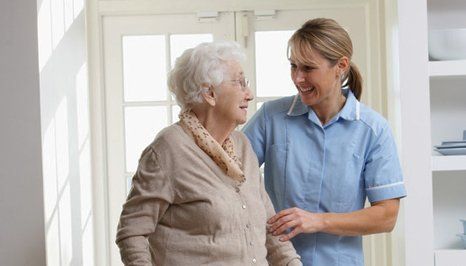 A nurse smiling with an old lady