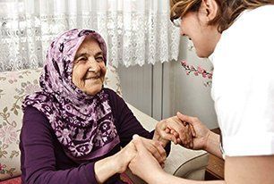 A nurse helping an old woman