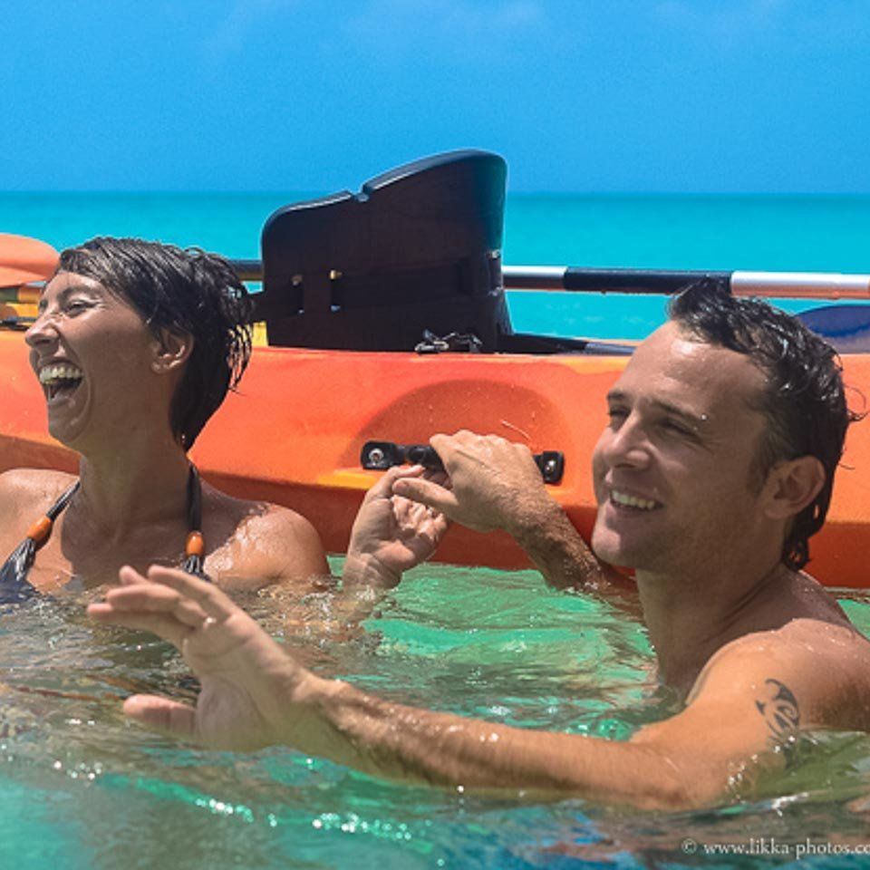 A man and a woman are in a kayak in the ocean