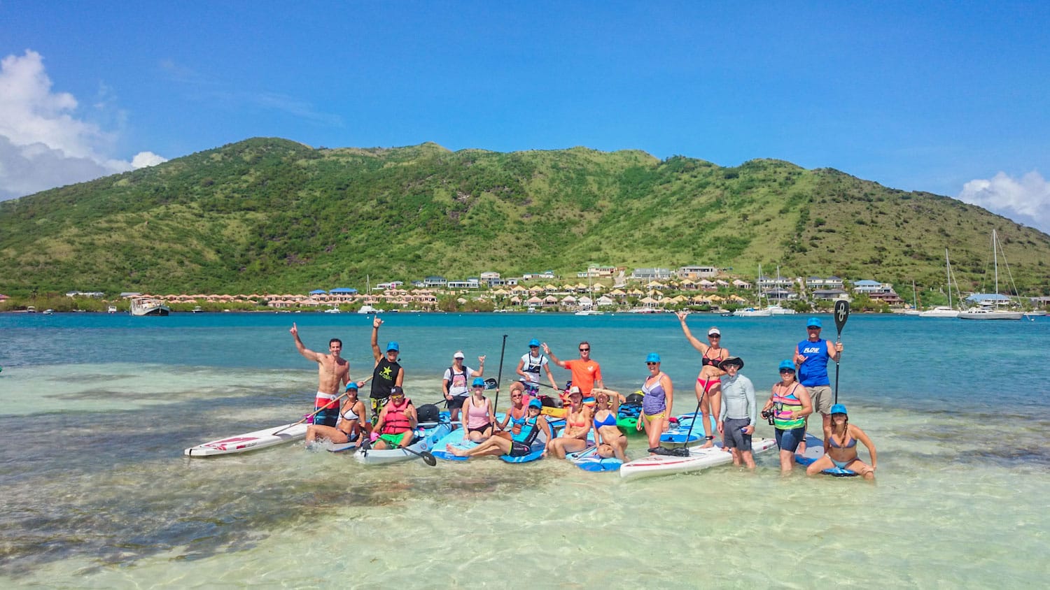 A group of people are posing for a picture on a beach.