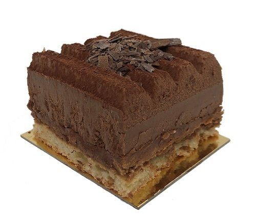 A piece of chocolate cake on a square plate on a white background.