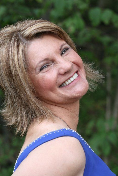 woman in blue dress side smiling