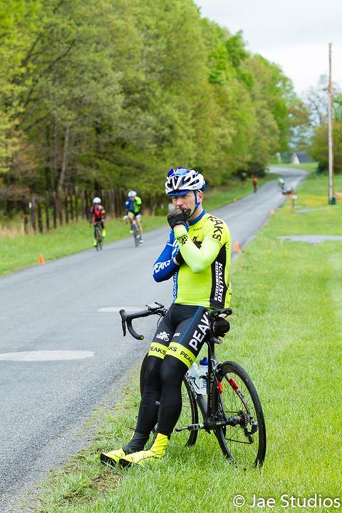A man is sitting on a bike on the side of a road.