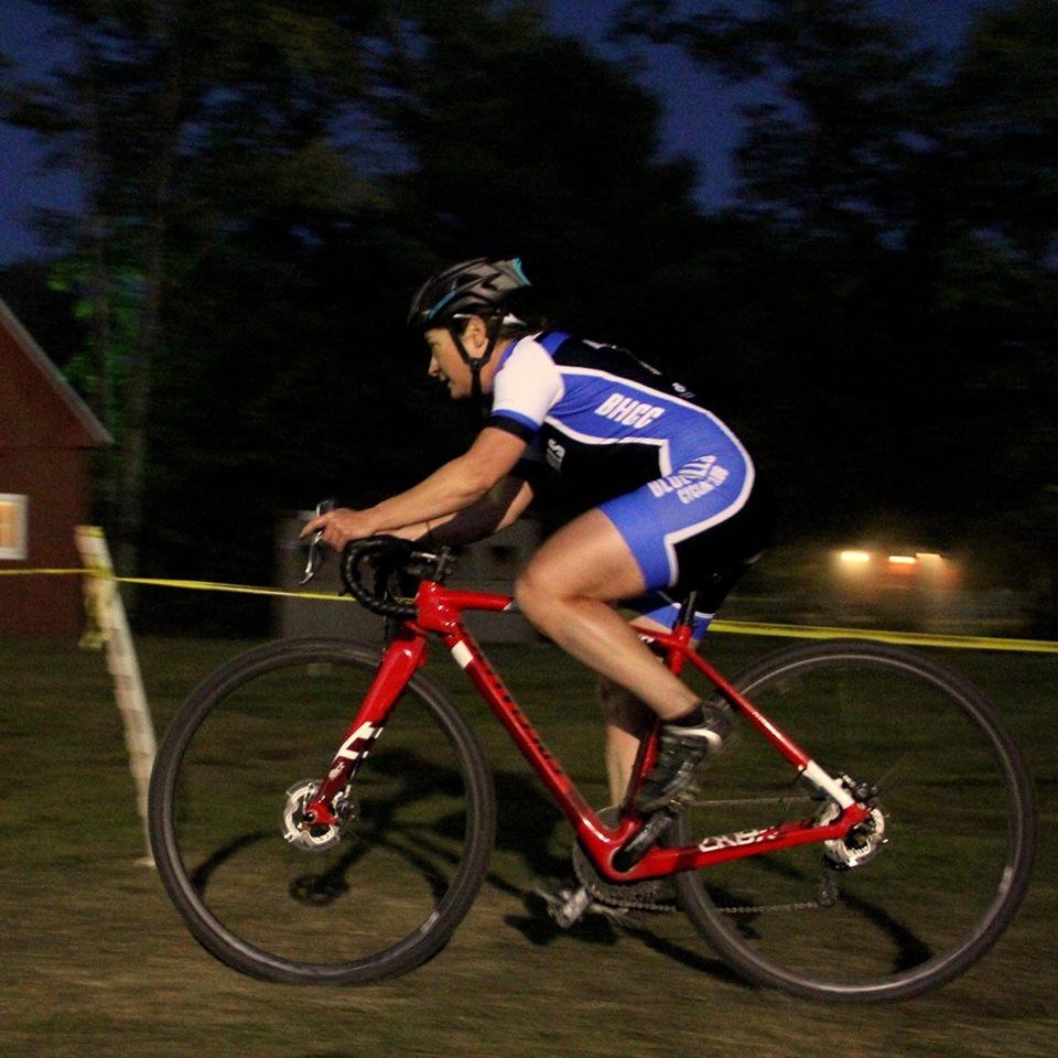 A person is riding a red bicycle with a helmet on