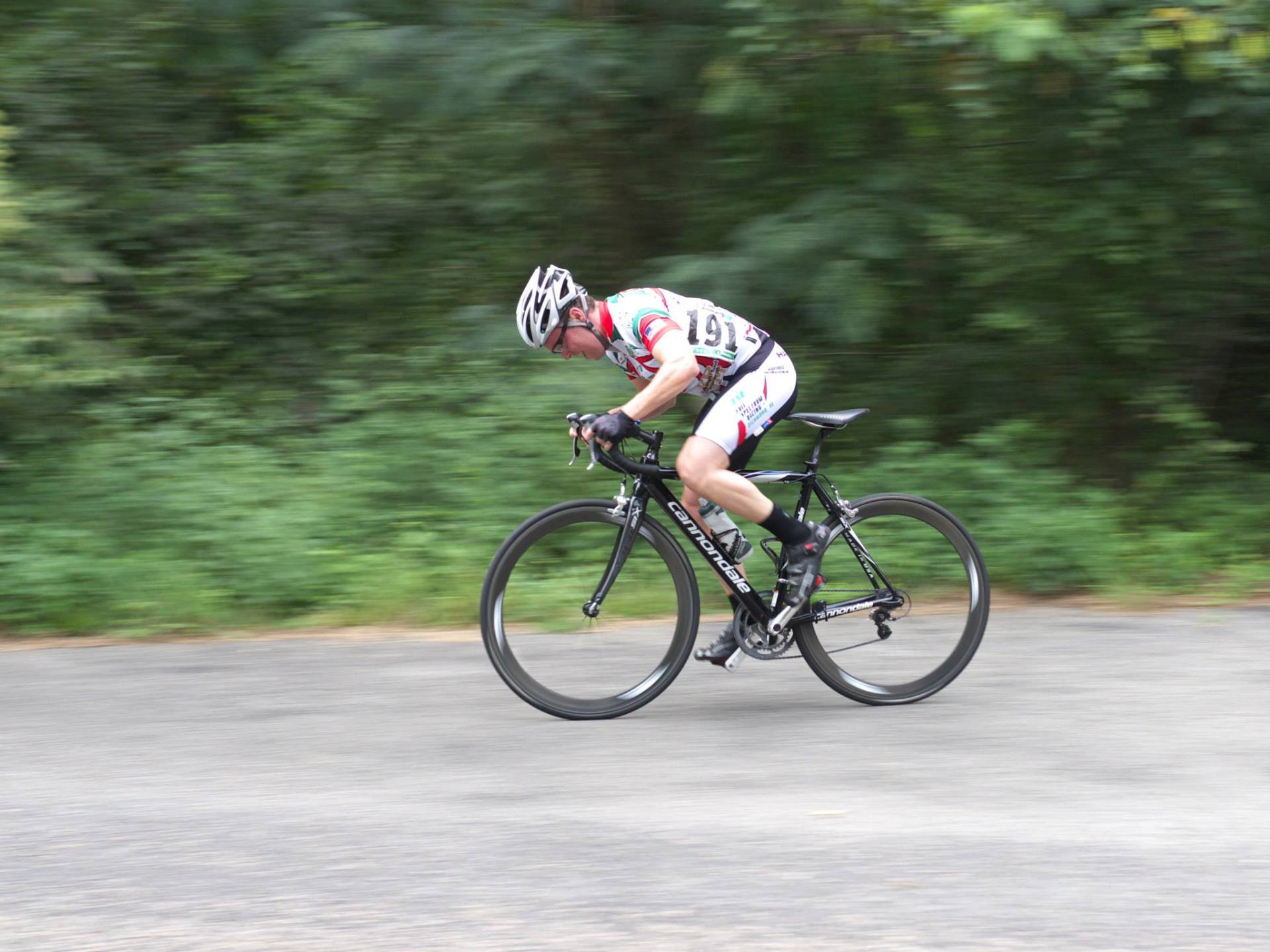 A man is riding a bike down a road.
