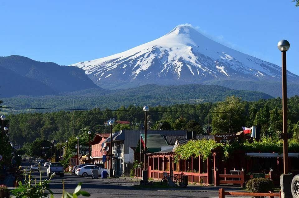A mountain covered in snow is behind a small town