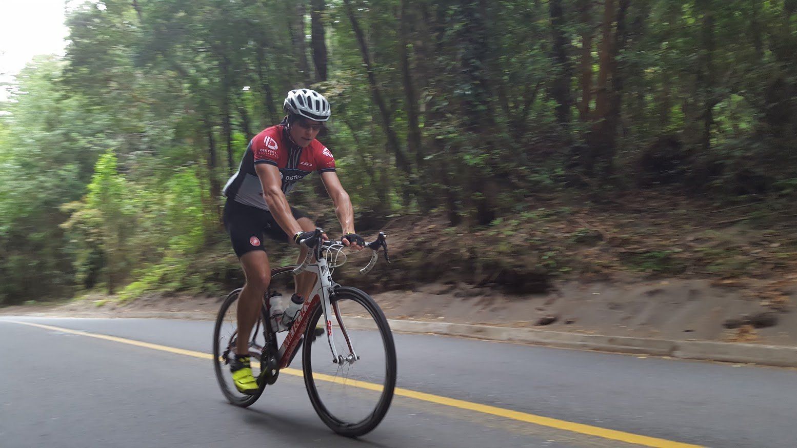 A man is riding a bike down a road.