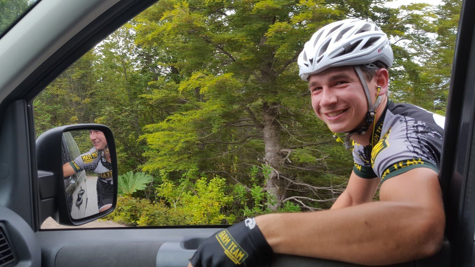 A man wearing a helmet is sitting in the driver 's seat of a car.