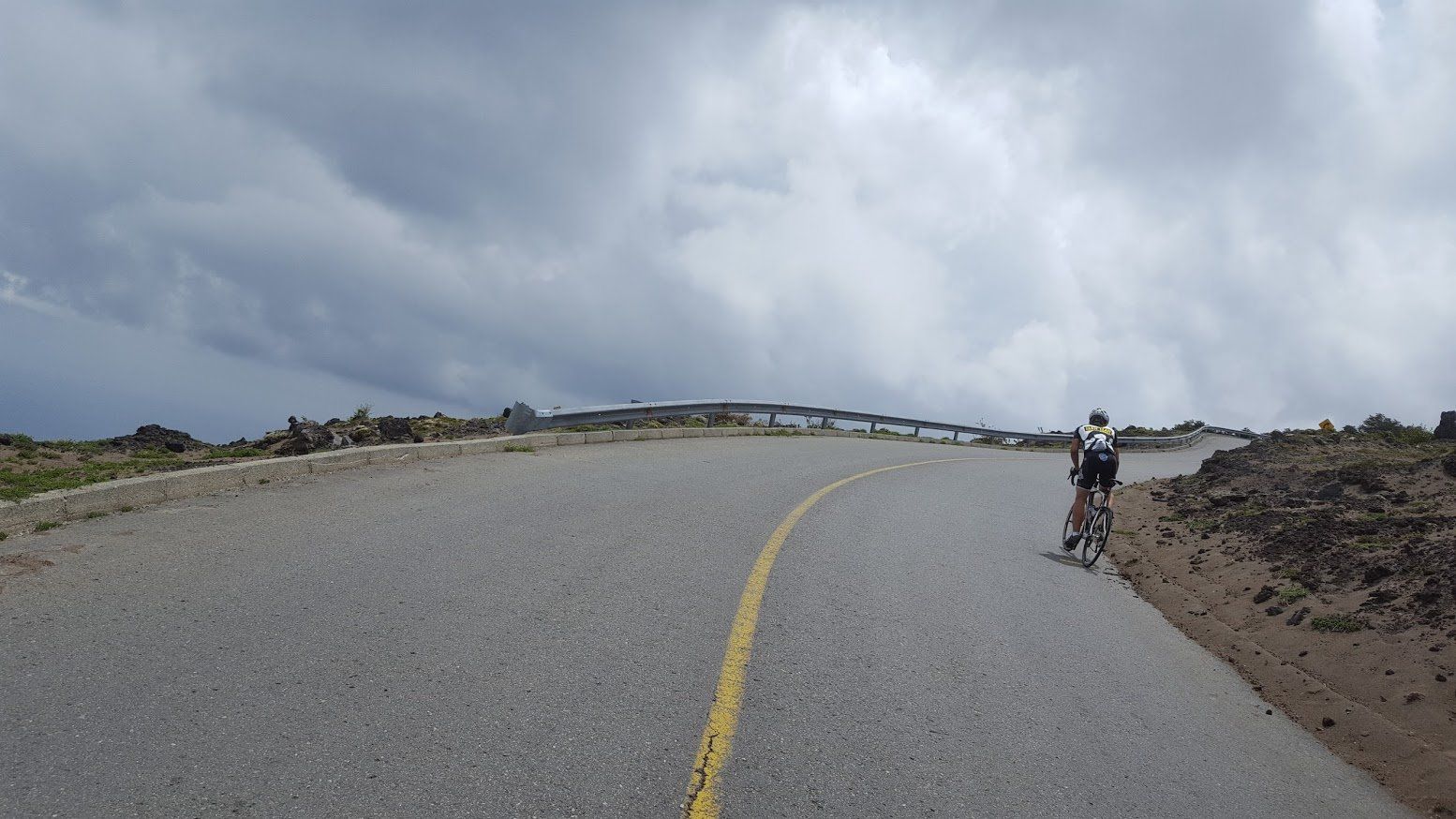 A person is riding a bike down a curvy road.