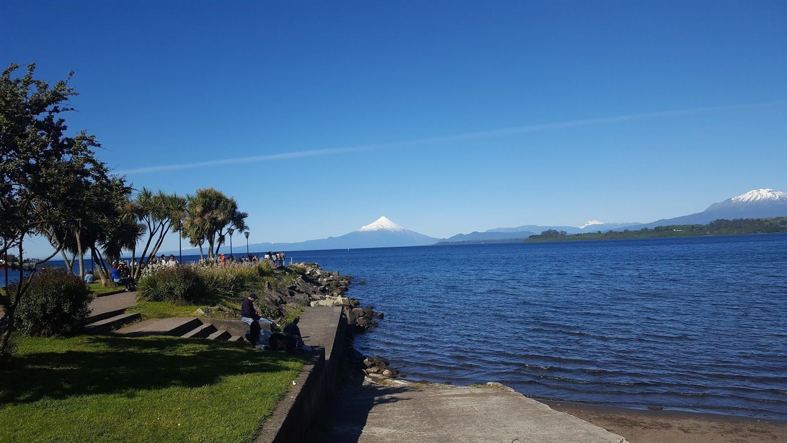 A lake with mountains in the background and a path leading to it