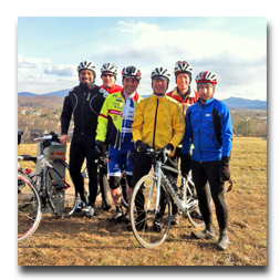A group of cyclists are posing for a picture with their bikes