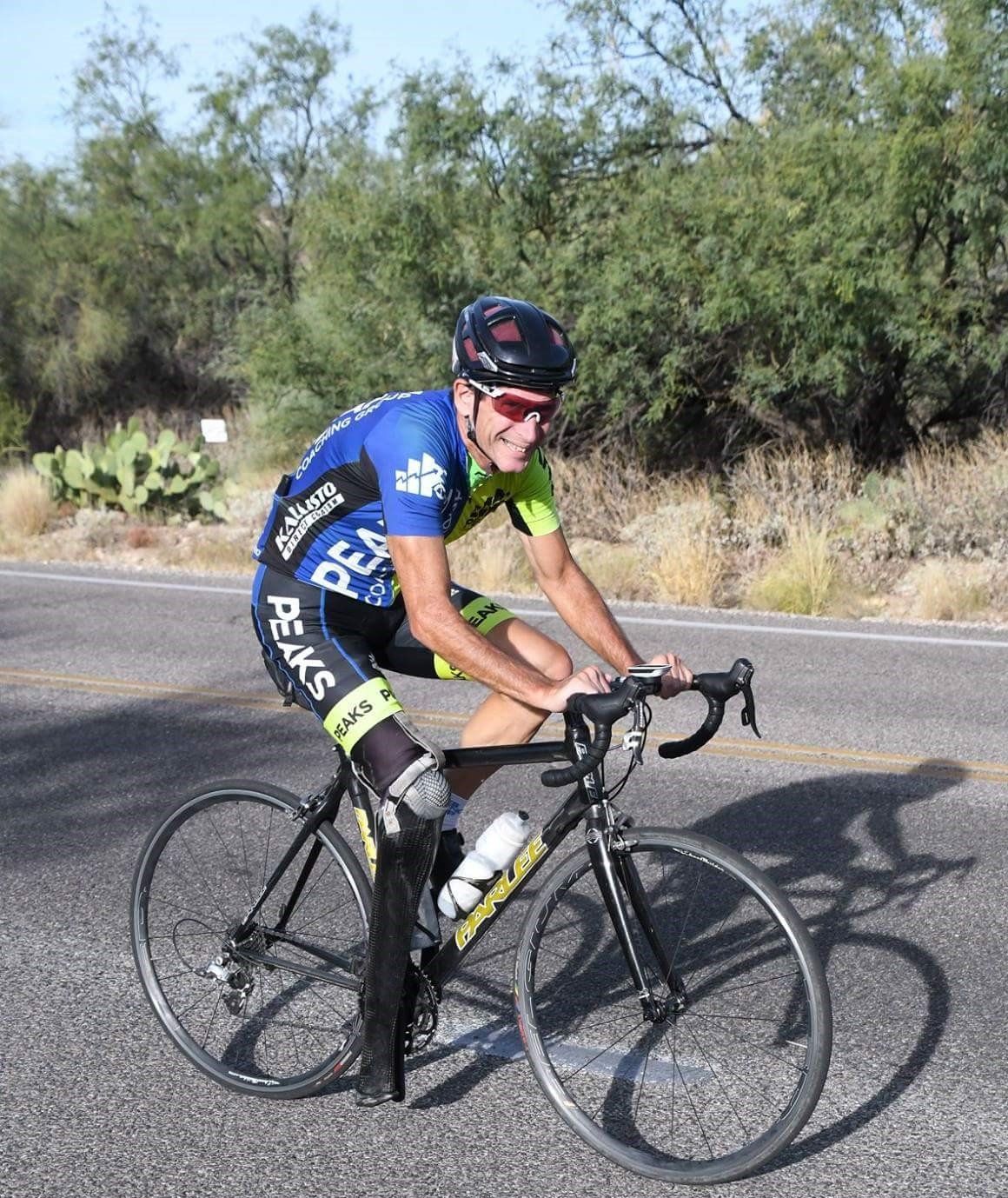 A man is riding a bike down a road.