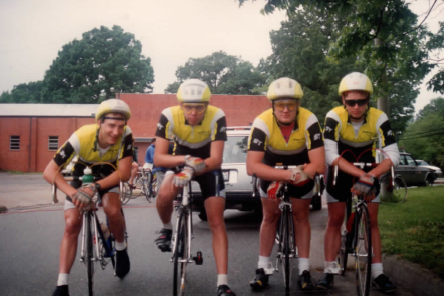 A group of men wearing helmets are riding bicycles