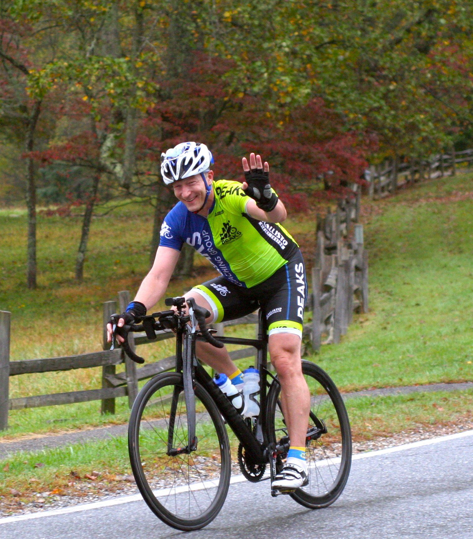 A man wearing a helmet is riding a bike down a road.