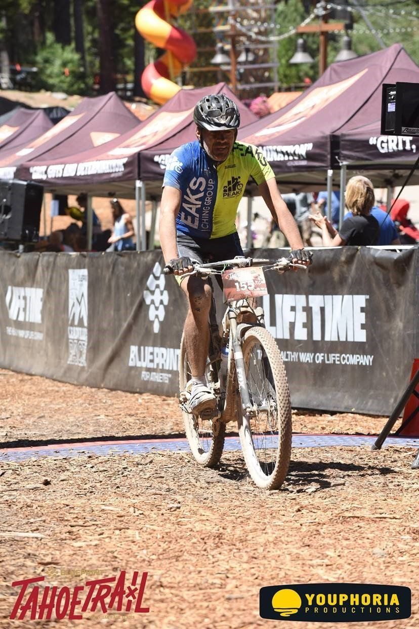 A man is riding a bike on a dirt road.